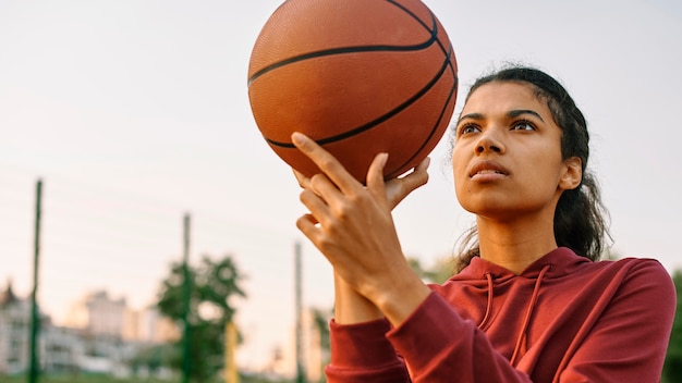 Young woman playing basketball outside