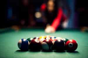 Free photo young woman playing billiard