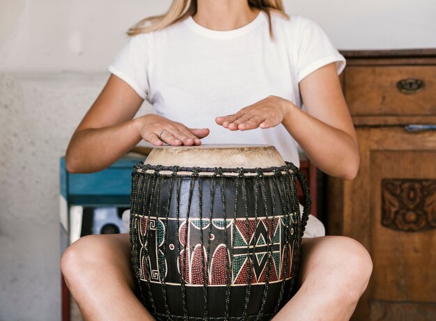 Молодая женщина играет барабан конга