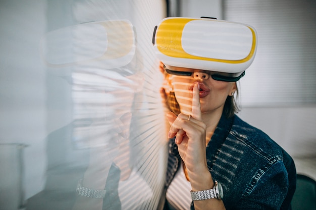 Young woman playing game through the VR glasses