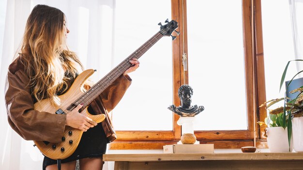 젊은 여자 집에서 기타를 연주