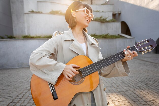 屋外でギターを弾く若い女性