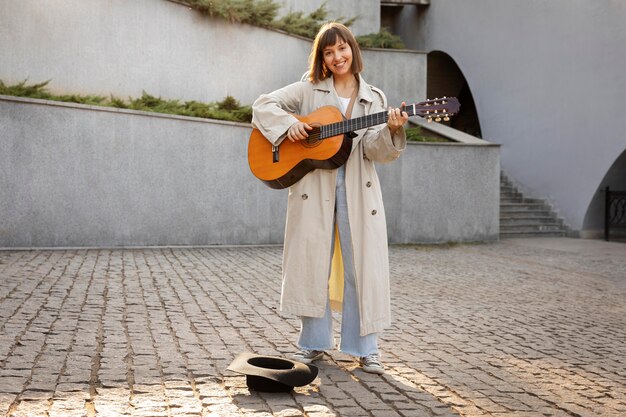 屋外でギターを弾く若い女性