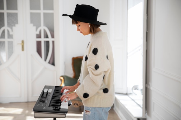 Giovane donna che suona il pianoforte in casa