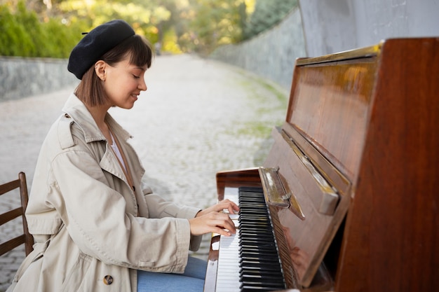 야외에서 피아노를 연주하는 젊은 여자