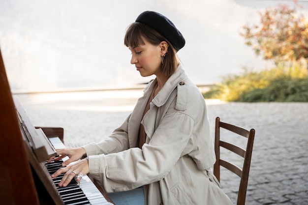 Young woman playing the piano outdoors