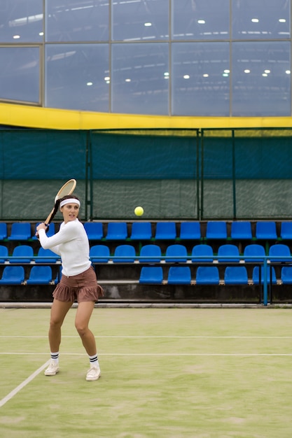 Giovane donna che gioca a tennis