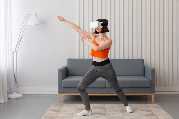 Young woman playing videogames while wearing virtual reality goggles