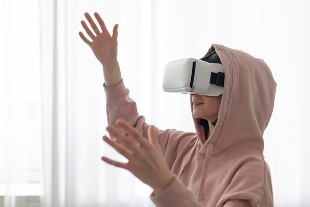 Young woman playing videogames while wearing virtual reality goggles