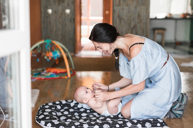 Free photo young woman playing with baby at home