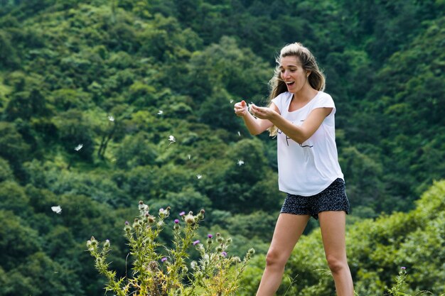 Young woman playing with flower petals in the wind