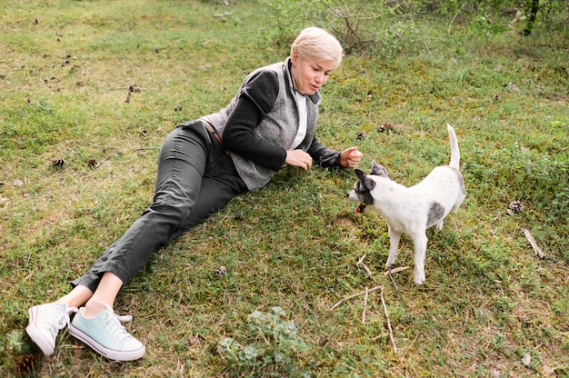 彼女の犬を屋外で遊ぶ若い女性