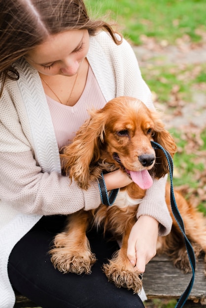 Free photo young woman playing with puppy