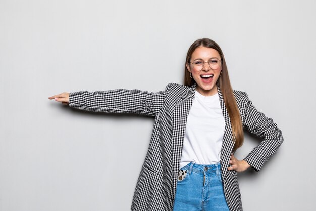 Young woman pointed side with a smile isolated