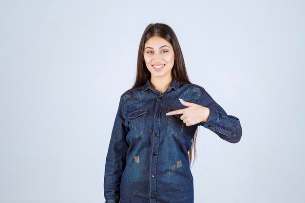 Young woman pointing at herself and smiling