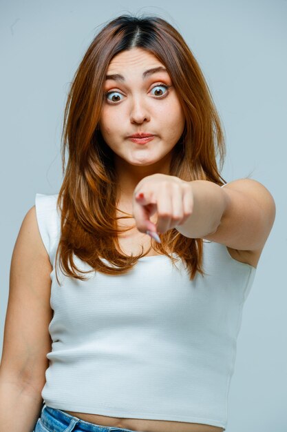 Young woman pointing and looking amazed