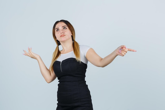 Young woman pointing right with index finger