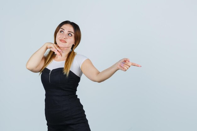 Young woman pointing right with index finger