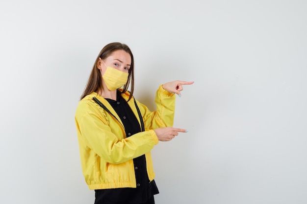 Young woman pointing right with index fingers