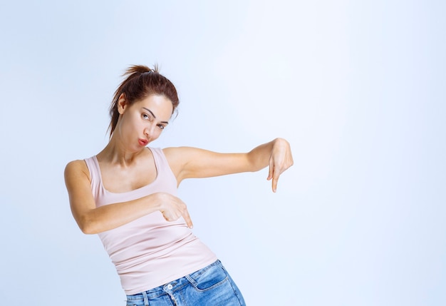 Young woman pointing at something in the downside