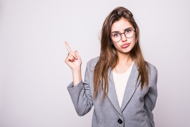 Young woman pointing up at copy space over white background