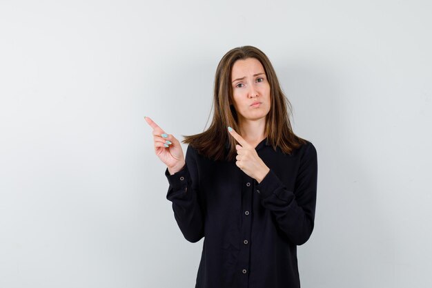 Young woman pointing up and looking disappointed