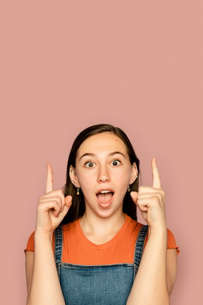 Young woman pointing up in surprised expression