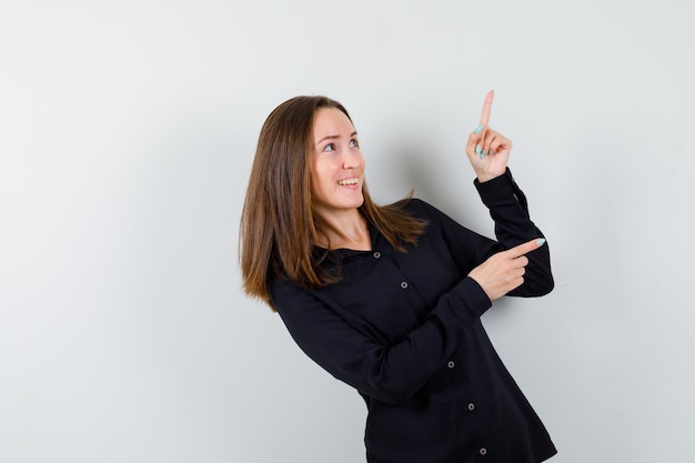 Young woman pointing up