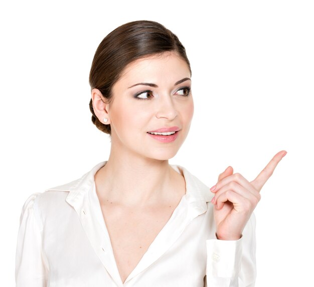 Young woman points to the side  in white shirt -  .
