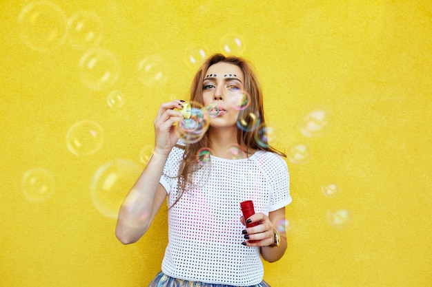 Young woman portrait blowing soap bubbles