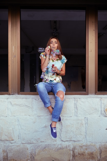 Free photo young woman portrait blowing soap bubbles