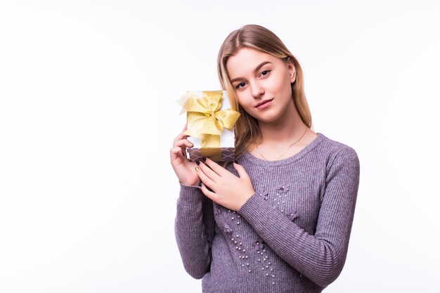 Young woman portrait hold gift in christmas . Smiling happy girl on white wall.