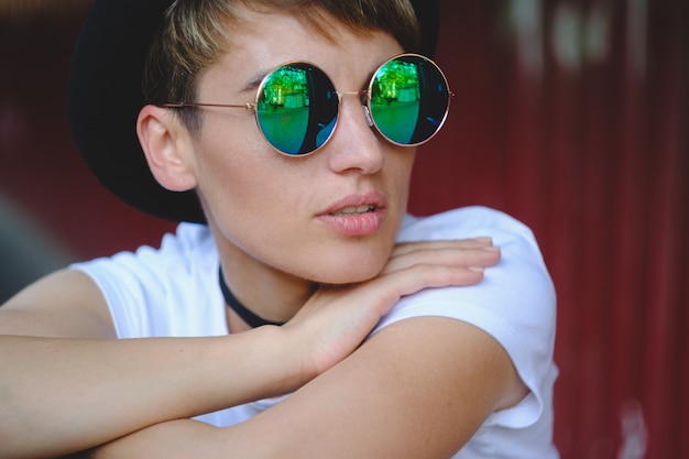 Young woman portrait wearing stylish hat and round glasses