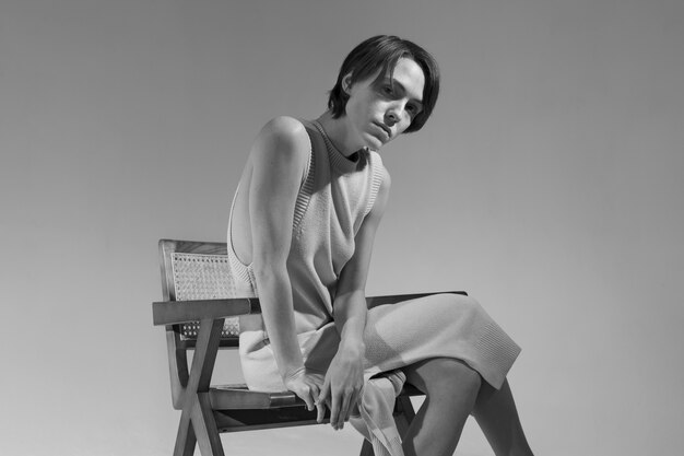 Young woman posing on chair side view