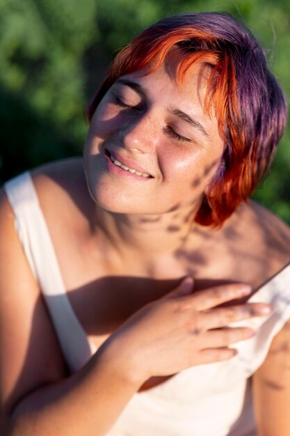 Free photo young woman posing confidently outdoors the field