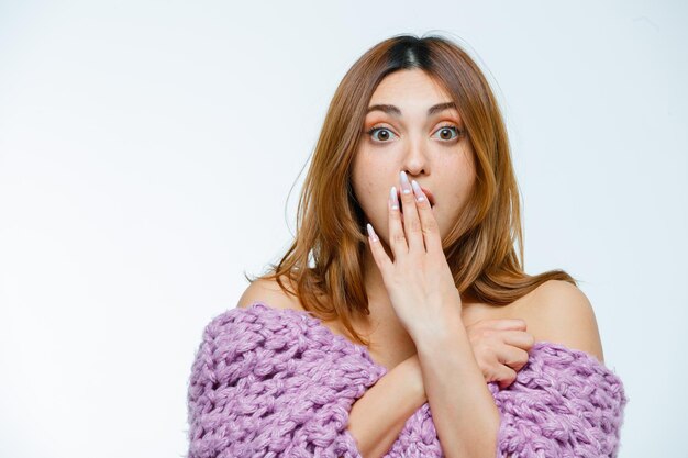 Young woman posing in knitwear and looking shocked