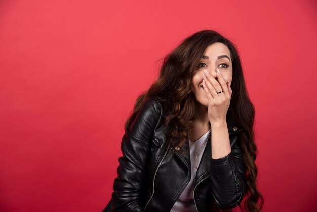 Free photo young woman posing on a red background. high quality photo