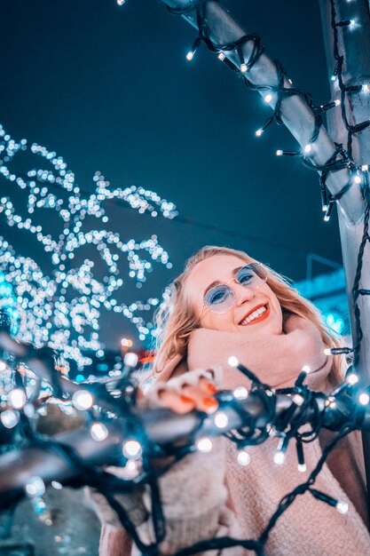 Young woman posing at the street with illuminated trees