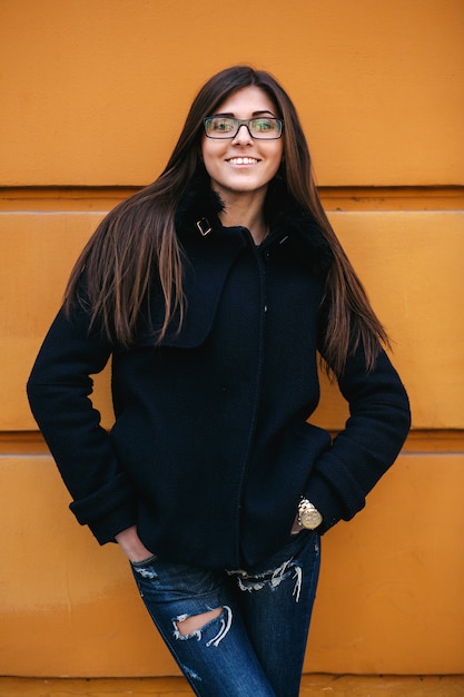 Free photo young woman posing on urban wall