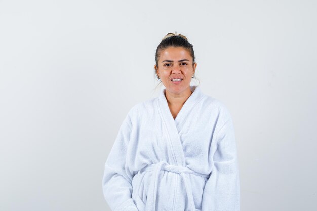 Young woman posing while standing in bathrobe and looking confident