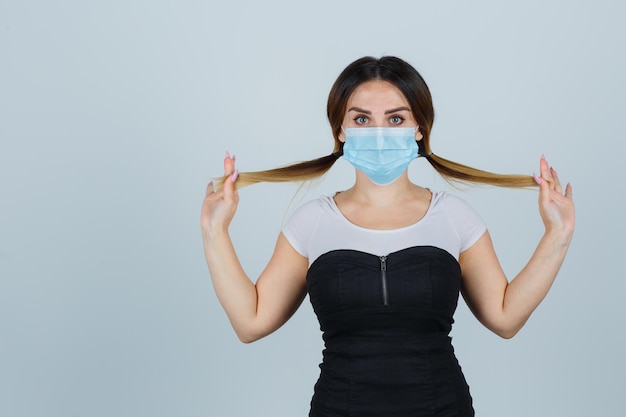 Free photo young woman posing while wearing mask