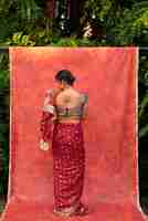 Free photo young woman posing while wearing traditional sari garment