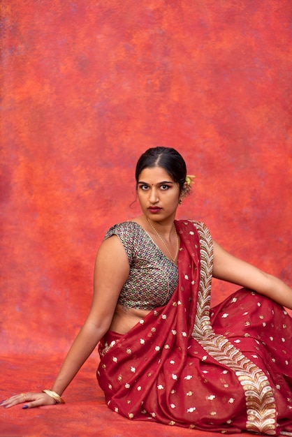 Free photo young woman posing while wearing traditional sari garment