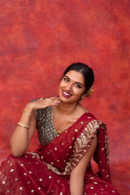 Free photo young woman posing while wearing traditional sari garment