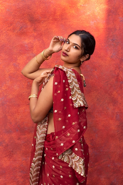 Free photo young woman posing while wearing traditional sari garment