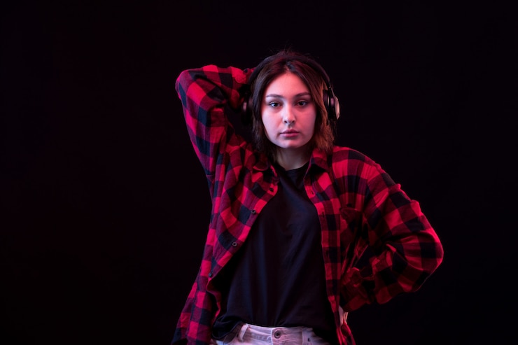 Free Photo young woman posing wiht checkered red and black shirt using headphones