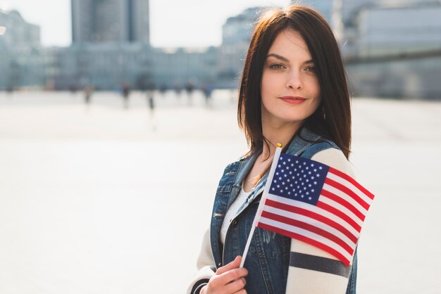 若い女性が7月4日の休暇中にアメリカの国旗とポーズ