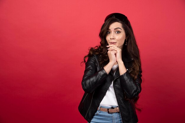 Young woman posing with black glasses on a red background. High quality photo