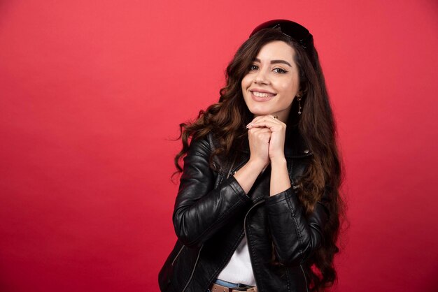 Young woman posing with black glasses on a red background. High quality photo