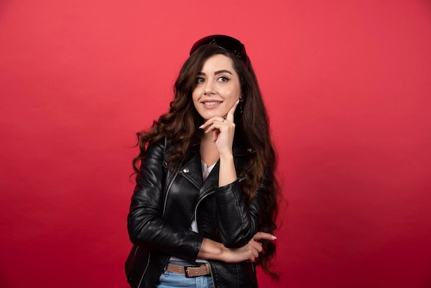 Young woman posing with black glasses on a red background. high quality photo